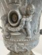 Lead urn on base with cherub detailing