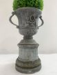 Lead urn on base with cherub detailing